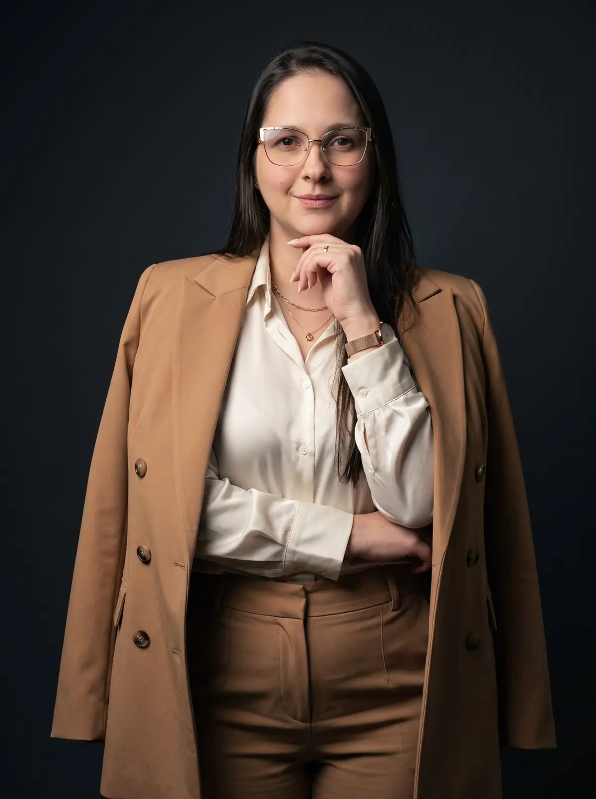 Retrato profissional de Izabella Andrade usando blazer em fundo escuro